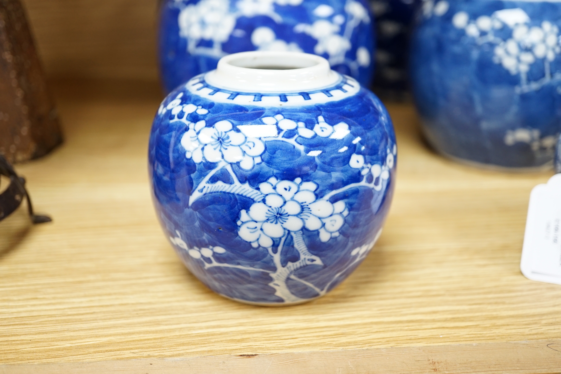 Five Chinese blue and white prunus ginger jars, one with cover- 15cm high and another jar
